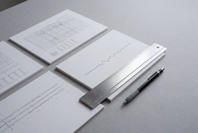 Printed EEG waveform charts and a ruler on a desk, with a pen resting alongside